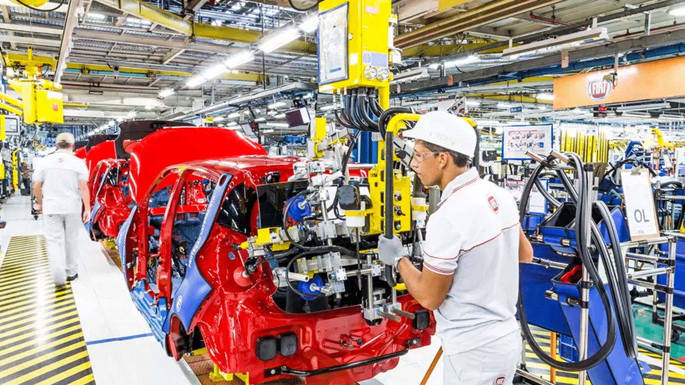 Funcionários operando na linha de montagem automotiva com auxílio de ferramentas pneumáticas movidas a ar comprimido.
