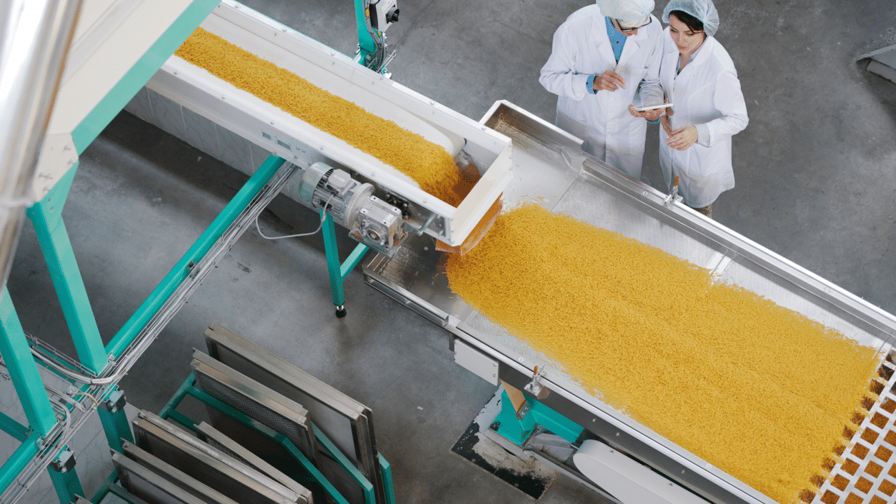 Pessoas olhando uma máquina de ar comprimido funcionando na indústria de alimentos e bebidas
