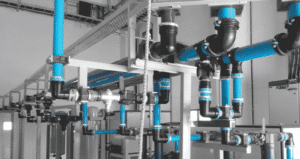 Técnico com um guia de boas práticas em uma sala de tubulações de ar comprimido.