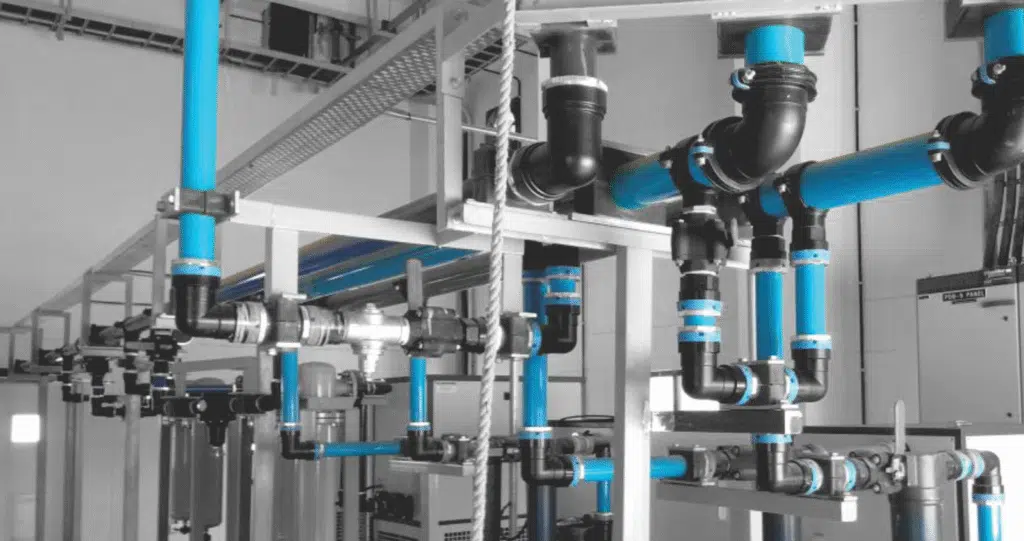 Guia completo de boas práticas em tubulação para ar comprimido 1 Técnico com um guia de boas práticas em uma sala de tubulações de ar comprimido.